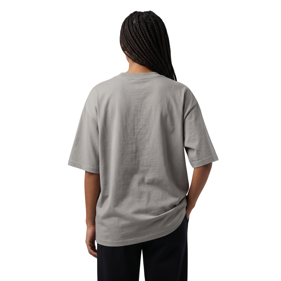 NILO Frame Loose Tee in grey cotton with drop shoulders, shown from the back on a model against a black background.