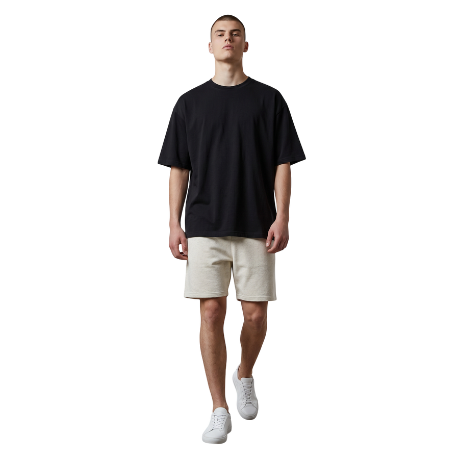 NILO Frame Loose Tee in black cotton with drop shoulders worn by a model with beige shorts and white sneakers