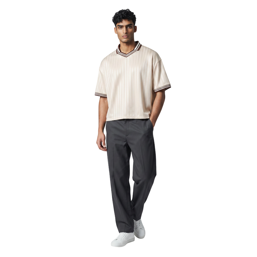 NILO Sequence striped polo tee in cream with brown trim, worn by a male model with dark grey trousers and white shoes.