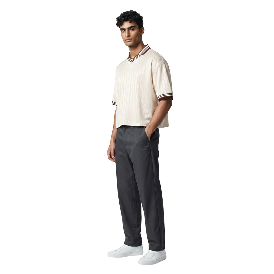 NILO Sequence striped polo tee in cream with brown trim worn by a male model with dark grey trousers and white sneakers