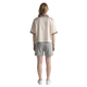 Back view of a woman wearing a NILO beige striped polyester polo tee with relaxed fit and grey shorts