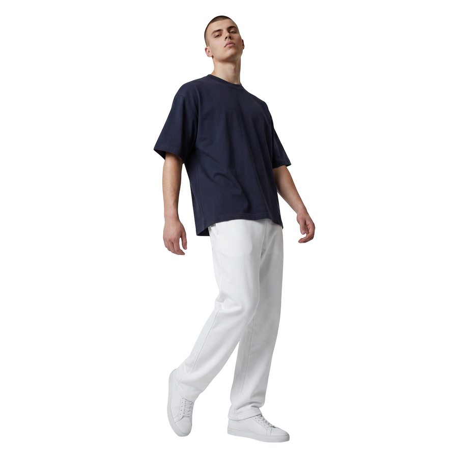 NILO Studio Heavyweight Tee in navy blue cotton with drop shoulders worn by a model with white joggers and sneakers.